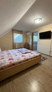 a bedroom with a bed and a flat screen tv at Роман in Berehove