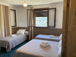 a room with two beds and a window at Hotel U Liccedu in Bustanico