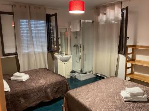 a small bathroom with two beds and a shower at Hotel U Liccedu in Bustanico +53 photos
