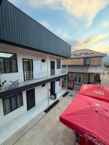 a red umbrella on a patio next to a building at Aydin Guest House in Bayetovka