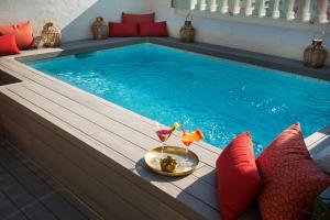 a swimming pool with a table and a drink on a wooden deck at Vincci Mae in Barcelona