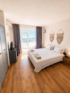 a large bedroom with a large white bed and wooden floors at Villa Smokinya in Sozopol