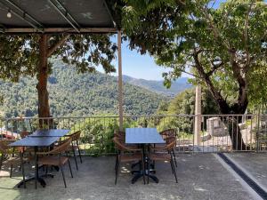 two tables and chairs on a balcony with a view at Hotel U Liccedu in Bustanico