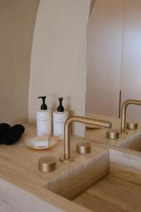 a bathroom sink with two bottles of soap and a mirror at VOUNO Santorini Private Villas in Pyrgos