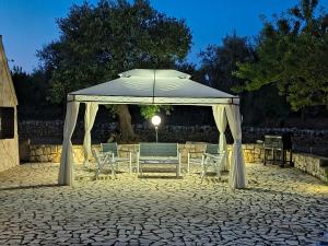a gazebo with chairs and a table and a tent at Villa Colle dei Trulli Monopoli in Monopoli