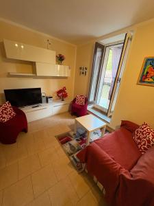 a living room with a red couch and a tv at Casa Raste in Lecco