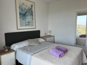 a bedroom with a bed with purple pillows on it at Panoramic 4 Apartments 2B in Castelldefels