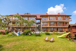 a large house with a playground in the yard at Dom Wczasowy Radość in Rewal