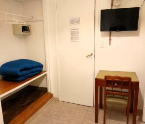a room with a table and a tv and a door at Hotel Medina y Mar BnB in Mar del Plata