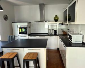 a kitchen with white cabinets and a black counter top at Apartmani Božica in Jadranovo