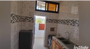 a kitchen with a sink and a window and a door at la perle de ngaparou in Saly Portudal