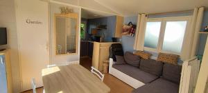 a living room with a couch and a table at vent de liberté 80 camping les peupliers in Vironchaux