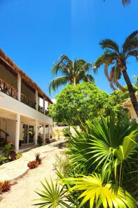 a resort with palm trees and a building at Villa Ixchel Tortugas in El Cuyo