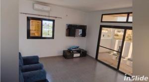 a living room with a blue chair and a glass door at la perle de ngaparou in Saly Portudal +11 photos