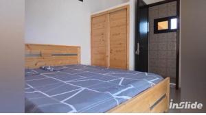 a bedroom with a blue bed with a wooden frame at la perle de ngaparou in Saly Portudal