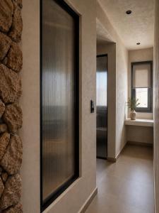 a hallway with a door and a stone wall at Ethos Suites in Agios Prokopios +38 photos