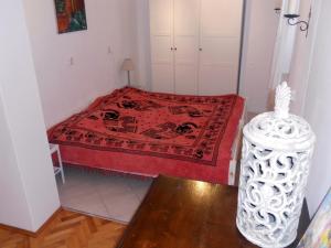 a small bedroom with a bed with a red blanket at Apartment Milano in Matulji