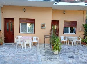 a patio with tables and chairs on a house at Lily's Studios in Nikiana