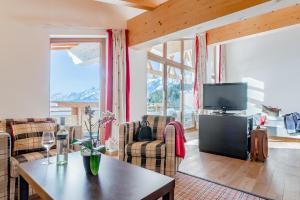 a living room with a table and a tv at Inntaler Hof in Seefeld in Tirol