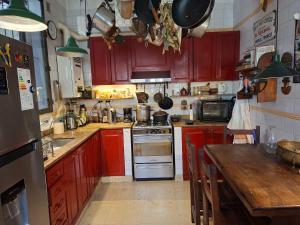 a kitchen with red cabinets and a wooden table at Corazón de Palermo Soho in Buenos Aires +21 photos
