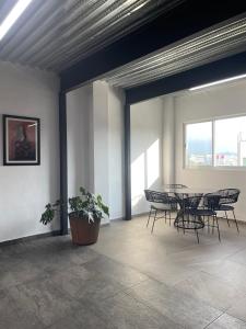 a room with a table and chairs and windows at Loft with Pool, Gym & A/C Suite in Querétaro