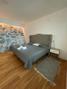 a bedroom with a bed and a stone wall at Loft with Pool, Gym & A/C Suite in Querétaro +11 photos