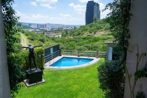 a statue of a woman standing next to a swimming pool at Loft with Pool, Gym & A/C Suite in Querétaro