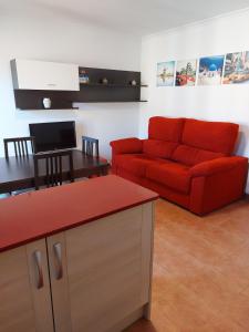 a living room with a red couch and a table at Casa Tia Nieves in Ruiloba