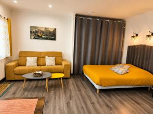 a bedroom with a bed and a couch and a table at Le cocondor - Design soigné et Parking facile in Montréjeau