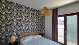 a bedroom with a bed and a patterned wall at LA PIETRA Residence in Trani