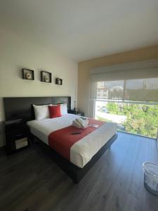a bedroom with a large bed with a large window at Penthouse with Pool, Gym & A/C in Querétaro +24 photos