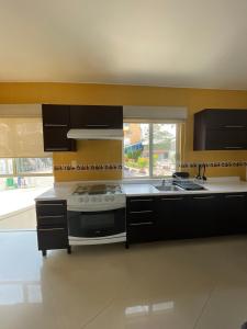 a kitchen with a stove and a sink at Penthouse with Pool, Gym & A/C in Querétaro