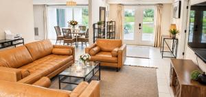 a living room with leather furniture and a dining room at SWISS 42 - Golf Course in Clermont