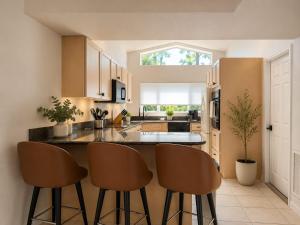 a kitchen with a counter and some chairs in it at SWISS 42 - Golf Course in Clermont