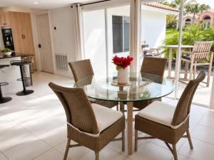 a glass table with chairs and a vase with a red flower at SWISS 42 - Golf Course in Clermont +26 photos