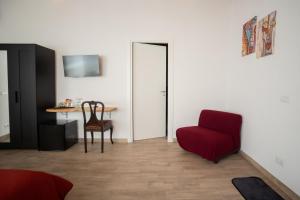 a living room with a red chair and a table at CASALE DILETTOSO Etna Relais in Randazzo