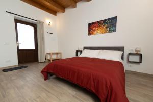 a bedroom with a large bed with a red blanket at CASALE DILETTOSO Etna Relais in Randazzo