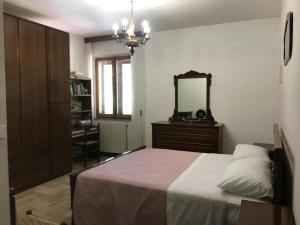 ein Schlafzimmer mit einem Bett mit Spiegel und einer Kommode in der Unterkunft Dimora Ferretti in Venarotta