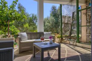 a patio with a couch and a table with wine glasses at Luma Luxury Apartment - 5 min Walk to the Beach in Sutomišćica