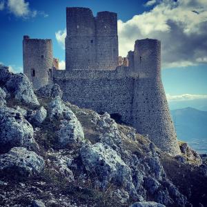 eine Burg auf einem Berggipfel mit Felsen in der Unterkunft Dimora Ferretti in Venarotta