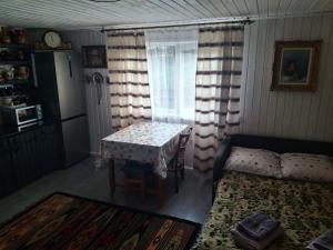 a living room with a table and a bed and a window at Бабусині маєтки in Lazeshchyna