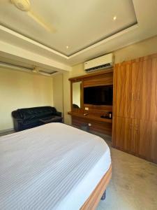 a bedroom with a bed and a flat screen tv at HOTEL SEBAA PALACE in Kanyakumari