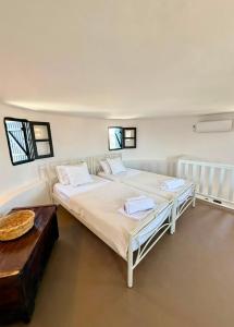 a bedroom with a large bed and a table at Casa Milos Windmill Alonissos in Alonnisos