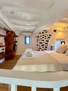 a large white bed in a room with a window at Casa Milos Windmill Alonissos in Alonnisos