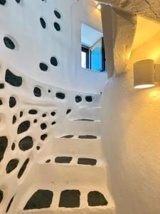 a room with a white wall with a rock wall at Casa Milos Windmill Alonissos in Alonnisos
