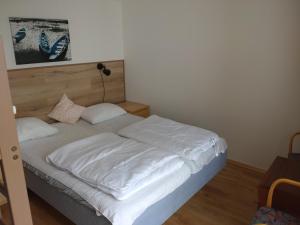 a bed with white sheets and pillows in a bedroom at Kungshamns Vandrarhem in Kungshamn