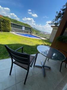 a glass table and chairs on a patio with a pool at Apartment with Pool, Gym & A/C in Querétaro