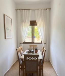 a dining room with a table and chairs and a window at Tirana Terminal Stay in Tirana