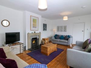 a living room with a couch and a fireplace at Faraway in Rhosneigr