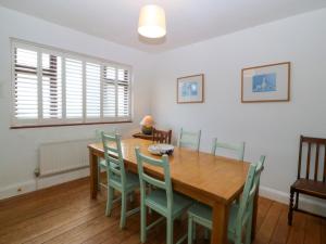 a dining room with a wooden table and chairs at Faraway in Rhosneigr
